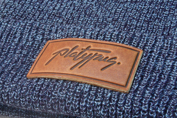 Close up of Platypus leather logo patch on Antique slate blue beanie