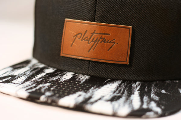 Close up of Platypus Clothing Signature leather patch Snapback Hat