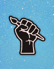 Designer independent protest punk raised fist with paint brush iron-on patch badge on blue