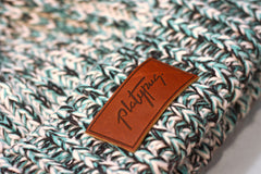 Close up of leather Platypus logo on big Knit beanie